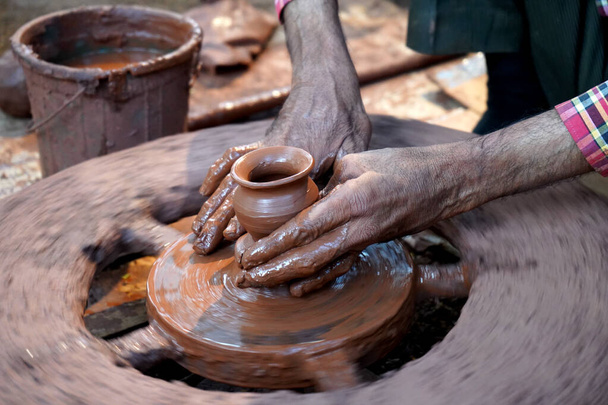 陶芸家の手は、ホイール上の土瓶を作成します。女性の手に導く陶芸家  - 写真・画像