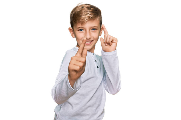 Malý kavkazský chlapec v neformálním oblečení, ukazující prsty na kameru se šťastnou a vtipnou tváří. dobrá energie a vibrace.  - Fotografie, Obrázek