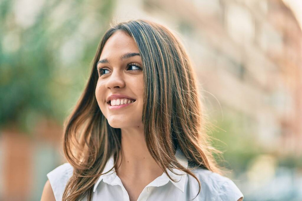 Gyönyörű latin tinédzser lány mosolyog boldog áll a városban. - Fotó, kép