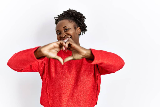 Jonge Afro-Amerikaanse vrouw draagt casual kleding over geïsoleerde achtergrond glimlachend in liefde doen hart symbool vorm met handen. romantisch concept.  - Foto, afbeelding