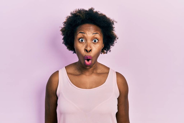 Young african american woman wearing casual sleeveless t shirt afraid and shocked with surprise expression, fear and excited face.  - Photo, Image