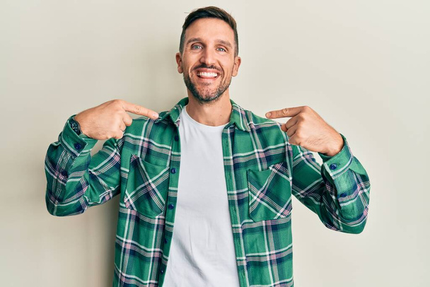 Handsome man with beard wearing casual clothes looking confident with smile on face, pointing oneself with fingers proud and happy.  - Photo, Image