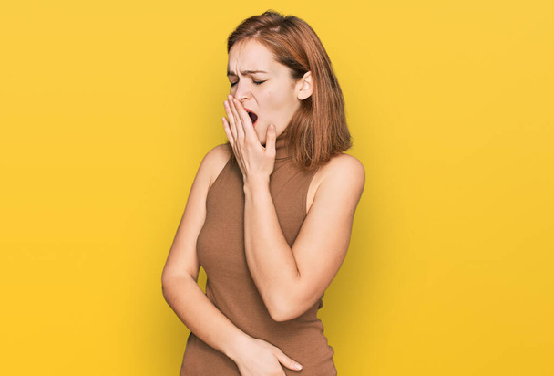 Mujer joven caucásica con ropa casual aburrida bostezando cansada cubriendo la boca con la mano. inquietud y somnolencia.  - Foto, imagen