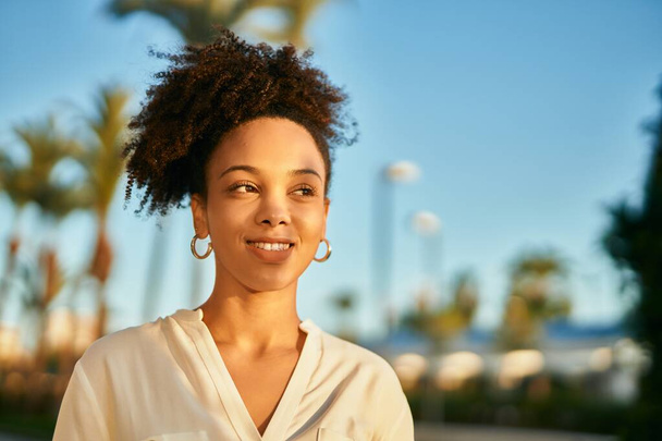 Молода афроамериканська комерсантка, яка радісно посміхається біля міста.. - Фото, зображення