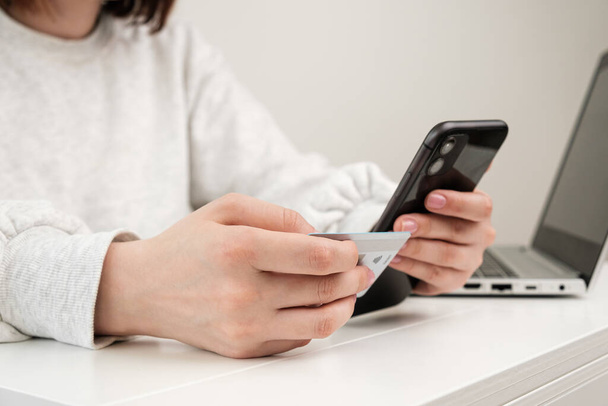 Lähikuva nainen käsi tilalla luottokortti ja älypuhelin tehdä ostoksia verkkokaupassa - Valokuva, kuva
