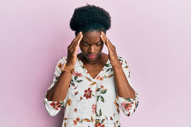 Nuori afrikkalainen amerikkalainen tyttö päällään rento vaatteita käsi pään päällä kipua päähän, koska stressi. migreeni.  - Valokuva, kuva