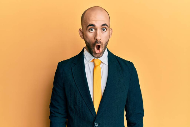 Young hispanic man wearing business suit and tie afraid and shocked with surprise expression, fear and excited face.  - Foto, Imagen