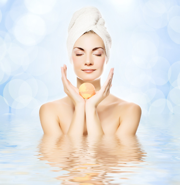 Mulher bonita com bola de banho de aroma refletida na água
 - Foto, Imagem