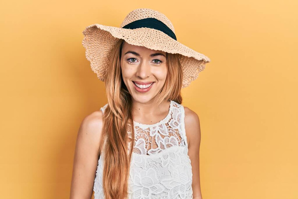 Giovane donna caucasica che indossa un cappello estivo con un sorriso felice e fresco sul viso. persona fortunata.  - Foto, immagini