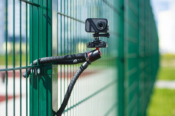 Compact action camera on a flexible tripod. Outdoor travel equipment - Foto, Imagem