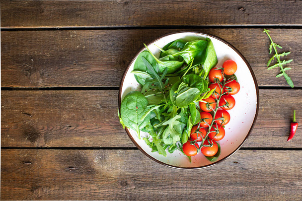 Tomaten Kirschsalat grüne Blätter frische Mischung grüner Spinat, Rucola, Salat gesunde Nahrung Mahlzeit kopieren Weltraumnahrung Hintergrund Keto oder Paläo-Diät vegane oder vegetarische Nahrung  - Foto, Bild