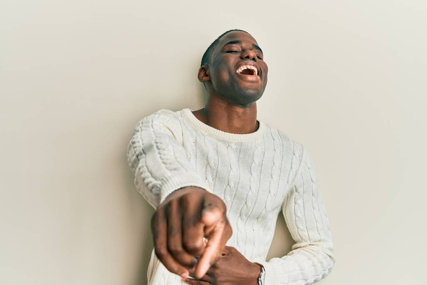 Junger afrikanisch-amerikanischer Mann in lässiger Kleidung lacht dich aus, zeigt mit der Hand über den Körper in die Kamera, schämt sich  - Foto, Bild