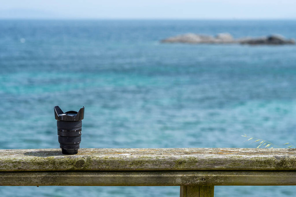 Analogowa czarna soczewka kątowa na drewnianym balustradzie nad morzem - Zdjęcie, obraz