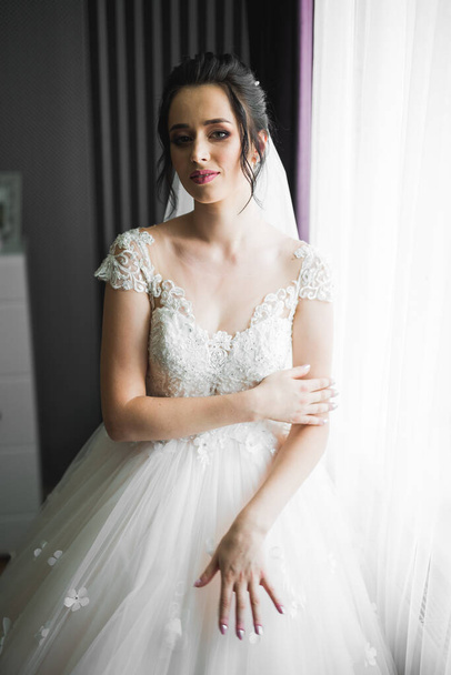 Luxury bride in white dress posing while preparing for the wedding ceremony - Foto, afbeelding