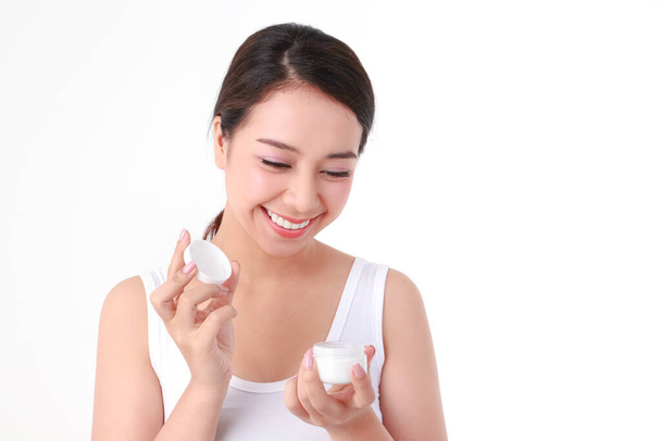 mooie aziatische vrouw hebben een mooie glimlach, schone witte tanden. Zorg voor de gezondheid van uw gezicht met huidcrèmes. Schoonheidsconcept. witte achtergrond - Foto, afbeelding
