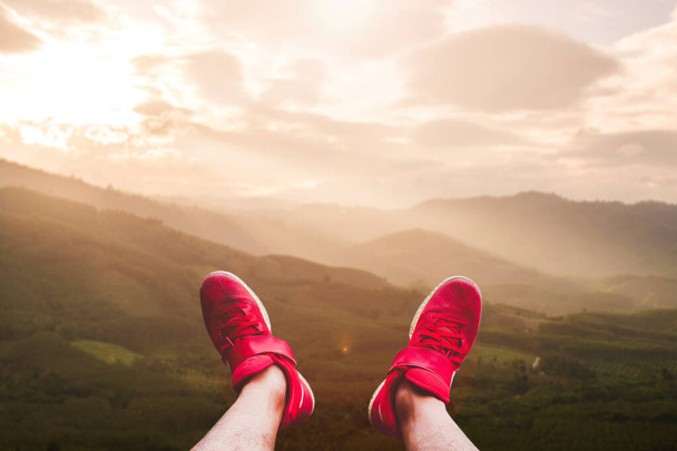 Czerwone buty turystyczne szczęśliwie rozszerzone w piękne krajobrazy. Pomysły na podróże po kryzysie Covid-19 - Zdjęcie, obraz