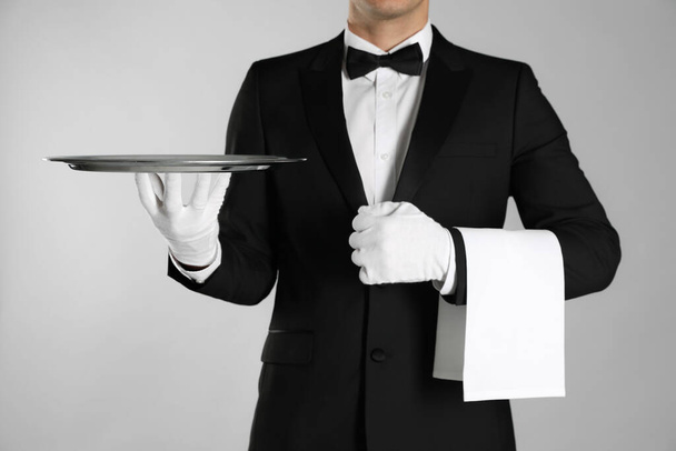Butler with tray on light grey background, closeup - Fotoğraf, Görsel