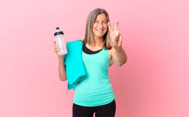 pretty middle age woman smiling and looking friendly, showing number two. fitness concept - Φωτογραφία, εικόνα