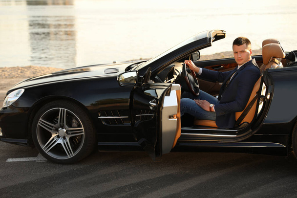 Young businessman in luxury convertible car outdoors - Φωτογραφία, εικόνα