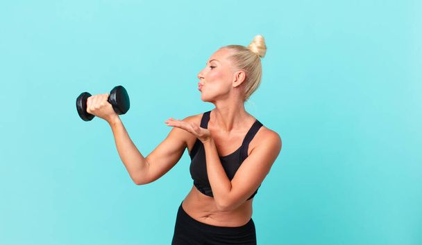 pretty adult woman with a dumbbell - Foto, imagen