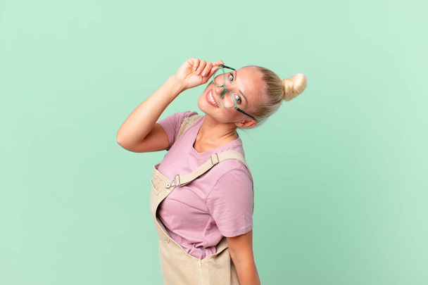 Portrait of blonde woman with glasses on green background - Foto, imagen