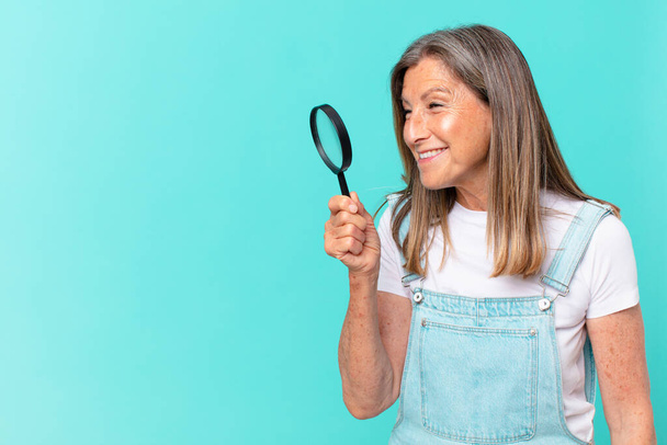 middle age pretty woman with a magnifying glass. search concept - Foto, Imagem