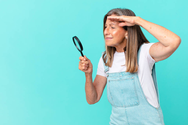 middle age pretty woman with a magnifying glass. search concept - Foto, Bild