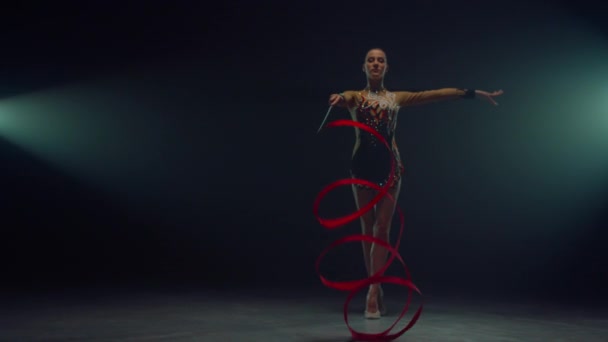 Sports woman twirling gymnastic ribbon. Flexible girl doing rhythmic gymnastics. - Footage, Video