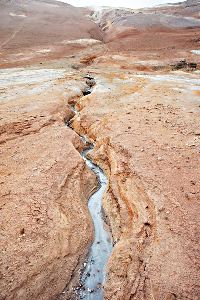 Геотермальная зона Гверира на севере Исландии, кипящие вулканические грязевые котлы и треснувшая красная земля - Фото, изображение