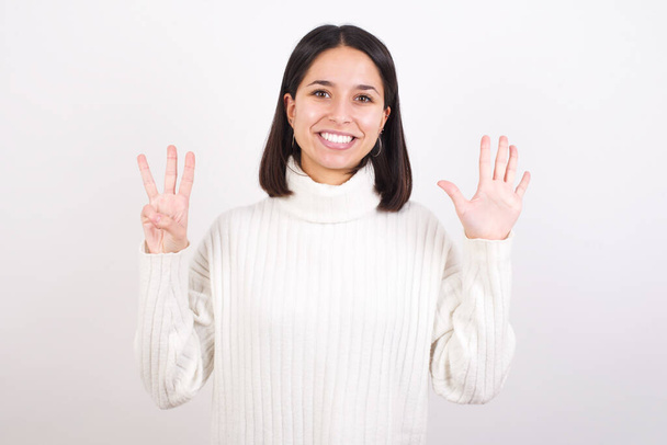 молода жінка показує і вказує пальцями номер вісім, посміхаючись впевнено і щасливо
. - Фото, зображення