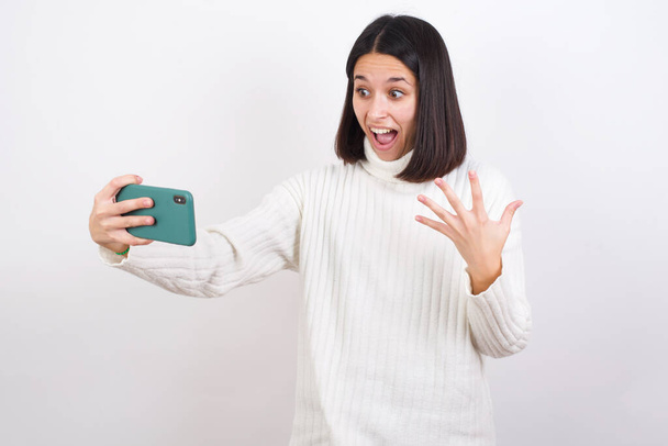 うわぁ！興奮した若い女性が携帯電話を開き手のジェスチャーで - 写真・画像