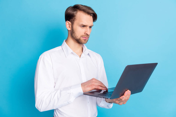 Photo of focused young man look laptop blogger work businessman concentrated face isolated on blue color background - Valokuva, kuva