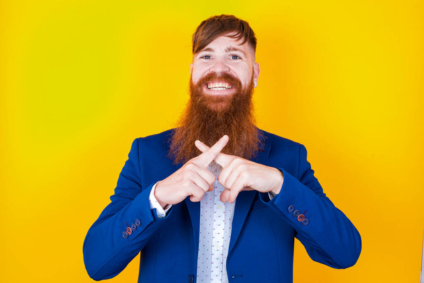 бородатый белый мужчина в синей куртке позирует на желтом фоне - Фото, изображение