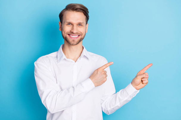 Photo of cheerful positive happy man point fingers empty space sale discount isolated on blue color background - Foto, Imagem