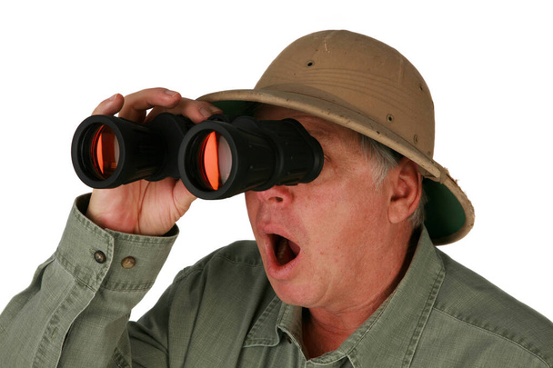 a man wearing a pith helmet looks through his binoculars. isolated on white. Explored using Binoculars. man using binoculars.  - Φωτογραφία, εικόνα