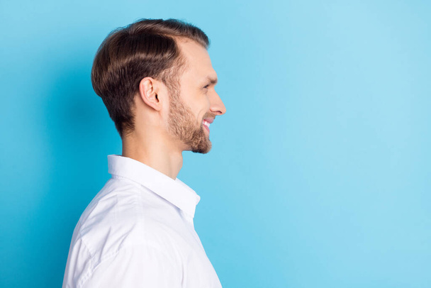 Profile side view portrait of attractive cheerful guy copy empty blank space place isolated over bright blue color background - Valokuva, kuva