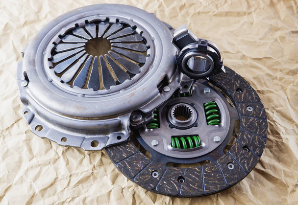 Car spare parts. Car clutch kit. Clutch disc, basket and clutch bearing. Car repair kit clutch manual gearbox on a background of craft paper. - Photo, Image
