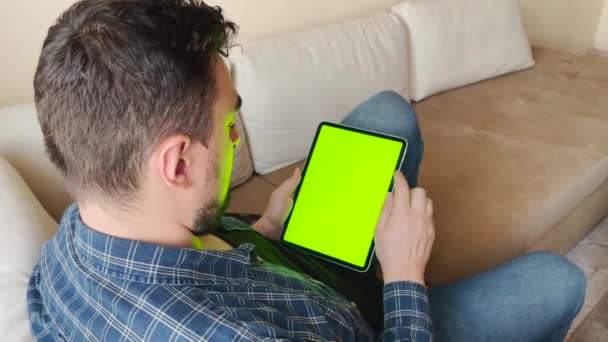 Τύπος που χρησιμοποιεί tablet με οθόνη αφής για σέρφινγκ on-line και e-mail ανάγνωση στο σπίτι - Πλάνα, βίντεο