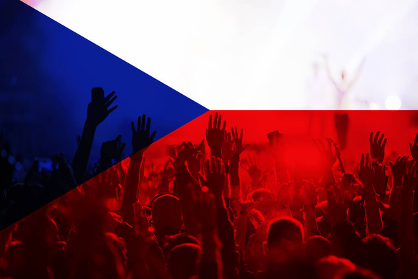 kibice piłki nożnej wspierający Czechy - tłum świętujący na stadionie z podniesionymi rękami przeciwko fladze Czech - Zdjęcie, obraz