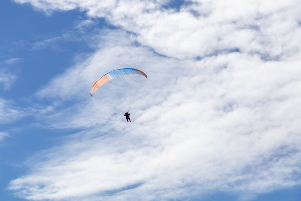 Adventurous Man Flying on a Paraglider around the mountains. - Fotografie, Obrázek