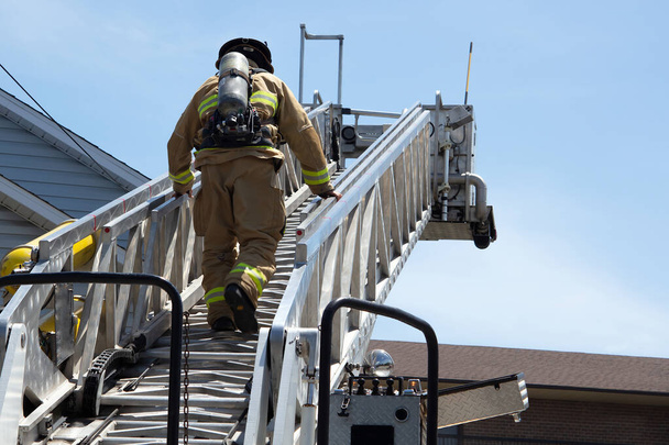 bombeiro escalando um bombeiro escada no trabalho extinguindo fogo - Foto, Imagem