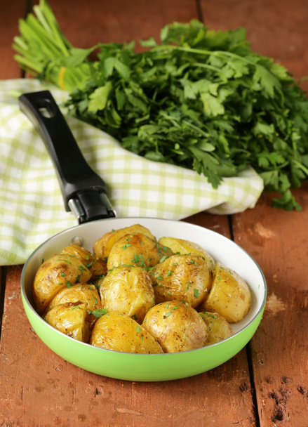 Batatas assadas saborosas com ervas na panela
 - Foto, Imagem