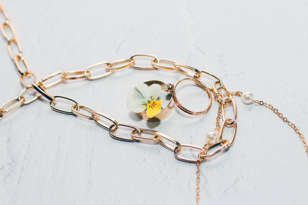 Trouwgouden ringen met sieraden met een bloem op een witte achtergrond. - Foto, afbeelding