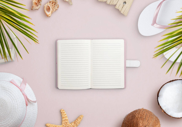 Notebook on beach surrounded by summer vacation accessories, shells and coconut. Empty notebook for text promotion - Foto, imagen