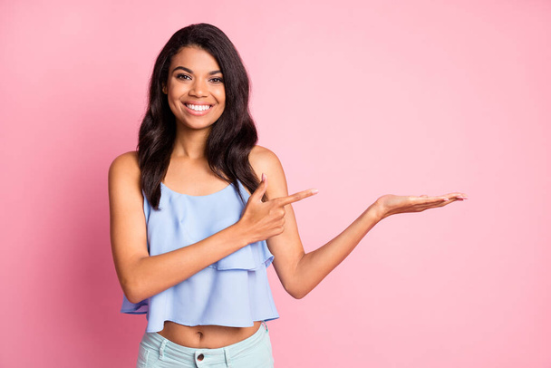Photo of optimistic brunette lady hold point empty space wear blue top isolated on pink color background - Photo, image