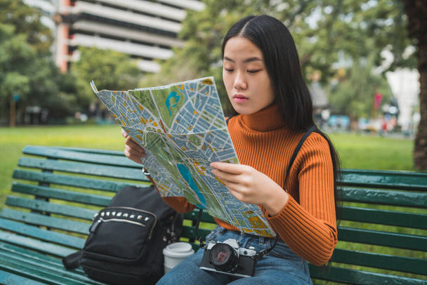 Asian woman looking at a map. - Fotografie, Obrázek