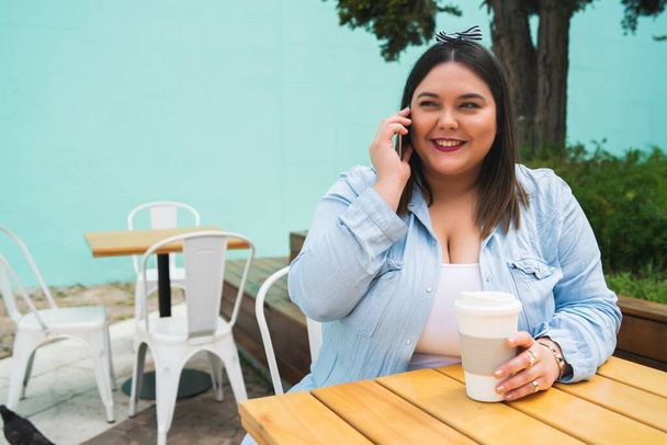 Young plus size woman talking on the phone. - Фото, изображение