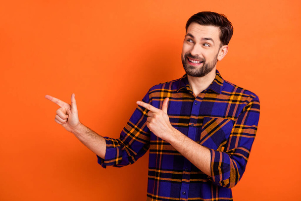 Photo of young guy happy smile look point fingers empty space advert advice choose promo isolated over orange color background - Fotografie, Obrázek