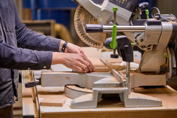 Carpenter using electric woodworking. close-up hands using electric equipment - Фото, изображение