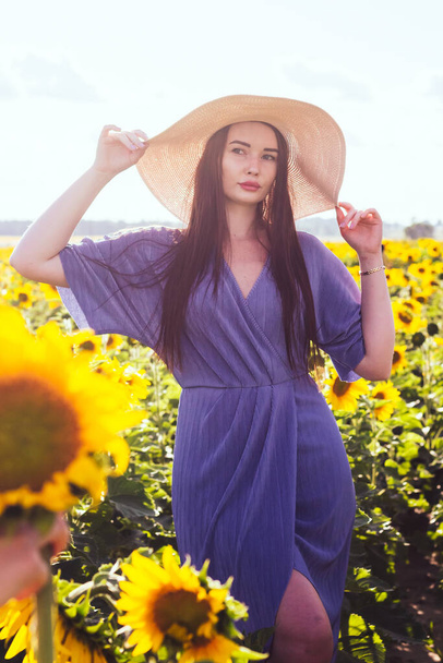 Beautiful Woman on the field with sunflowers. Yellow sunflowers. Close plan. - Foto, Imagen